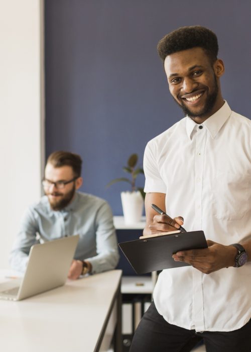 black-man-with-clipboard-near-colleagues